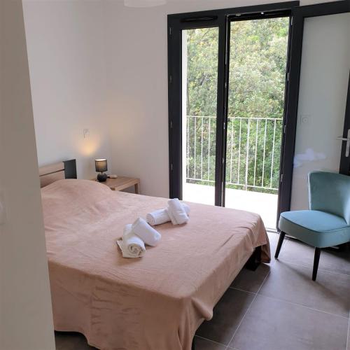 - une chambre avec un lit, une chaise bleue et une fenêtre dans l'établissement Villa Leku Lucia 8 pers piscine chauffée 15 min plage en voiture, à Sainte-Lucie de Porto-Vecchio