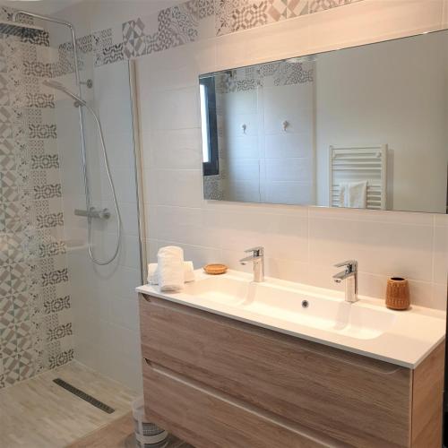 une salle de bain avec un lavabo et une douche avec un miroir dans l'établissement Villa Leku Lucia 8 pers piscine chauffée 15 min plage en voiture, à Sainte-Lucie de Porto-Vecchio