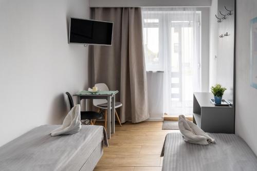 a bedroom with two beds and a desk and a television at Marinas Rewa in Rewa