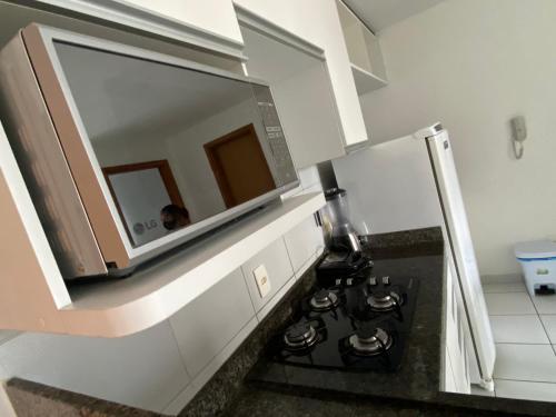 a kitchen with a stove with a mirror above it at Flat Parque Jaqueira Home Service in Recife