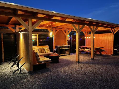 a wooden pergola with a bench and a table at Beach House 9 in Scharendijke