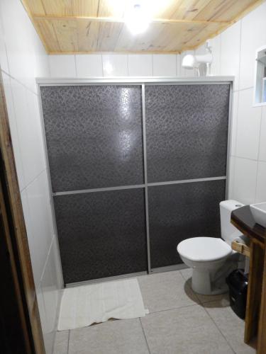 a shower stall in a bathroom with a toilet at Pousada Rural Paiol dos Pellizzaro in Concordia