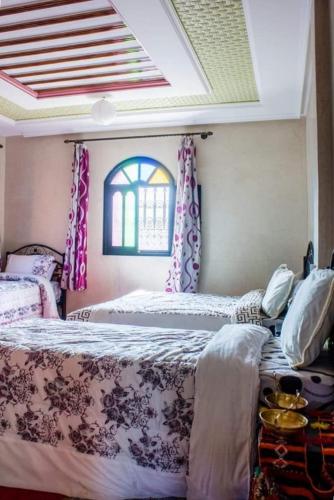 a bedroom with two beds and a window at riad lala fatima in Ouzoud