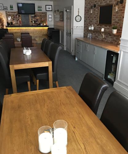 a dining room with two tables and a bar at Chadberry House Hotel in Blackpool