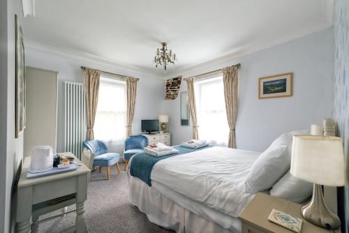 a bedroom with a bed and a desk and a chair at Garth Dderwen in Betws-y-coed