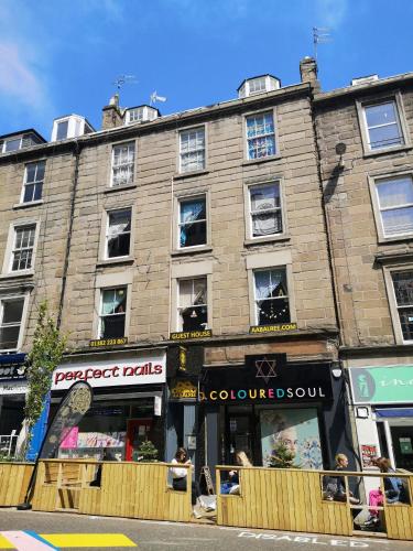 a large brick building with a store front at aabAlree Guest House in Dundee