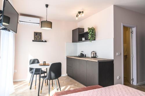 una cucina con tavolo e sedie in una stanza di Apartmani MiS a Šabac