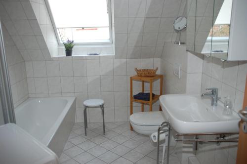 een badkamer met een bad, een toilet en een wastafel bij Zur Hanse Wohnung 4 5 - Zur Hanse West in Zingst