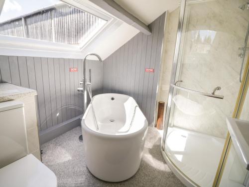 a bathroom with a large tub and a shower at Coombs View in Low Hesket