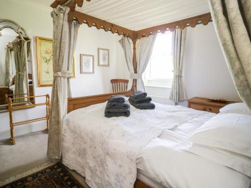 a bedroom with a canopy bed with towels on it at Coombs View in Low Hesket