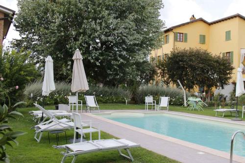 una piscina con sillas y sombrillas junto a un edificio en Apartments in Lucca/Toskana 23966, en San Cassiano a Moriano