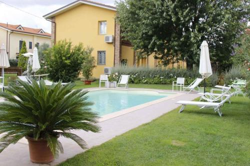 a swimming pool with lounge chairs and a house at Apartments in Lucca/Toskana 23966 in San Cassiano a Moriano