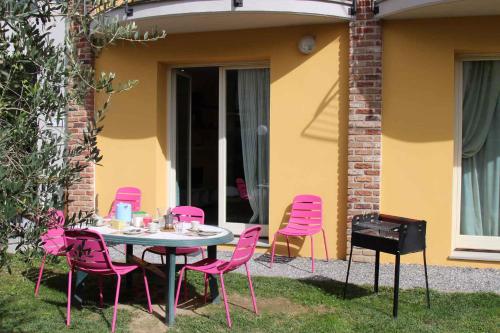 una mesa y sillas rosas sentadas en un patio en Apartments in Lucca/Toskana 23966, en San Cassiano a Moriano