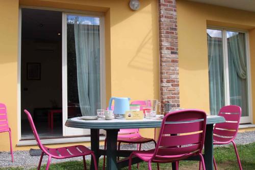 una mesa con sillas rosas frente a una casa en Apartments in Lucca/Toskana 23966, en San Cassiano a Moriano