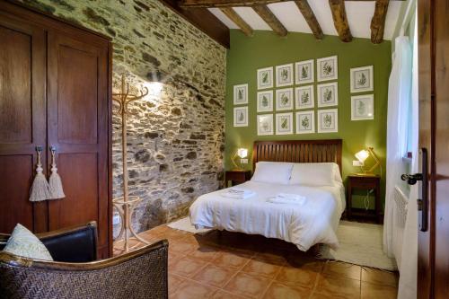 a bedroom with a bed and a green wall at Aldea A Paínza in Arzúa