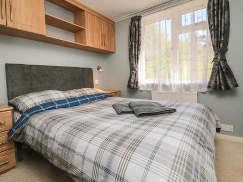 a bedroom with a bed and a window at Valley Lodge in Tiverton