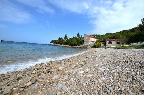 a rocky beach with houses and the water at Apartment Anica in Štivan
