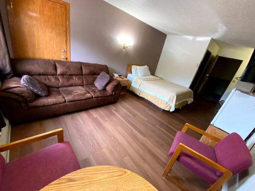 a living room with a couch and a bed at Woodland Inn & Suites in Medford