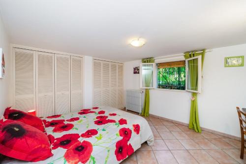 a bedroom with a bed with red flowers on it at Maison d'une chambre avec jardin clos et wifi a Arles sur Tech in Arles-sur-Tech