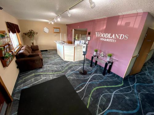 a living room with a couch and a pink wall at Woodland Inn & Suites in Medford