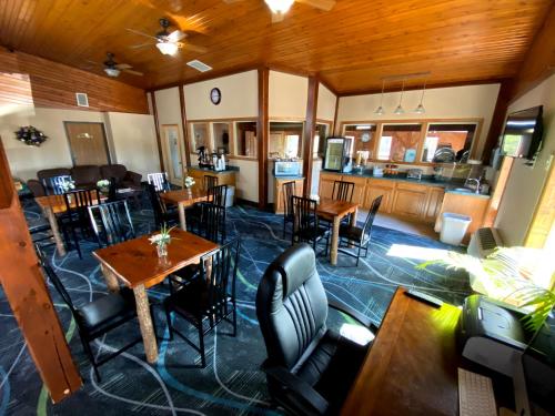 a living room with tables and chairs and a kitchen at Woodland Inn & Suites in Medford