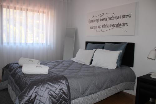 um quarto com uma cama com uma placa na parede em Casa Sandra - Apartamento Mariana em Lousã