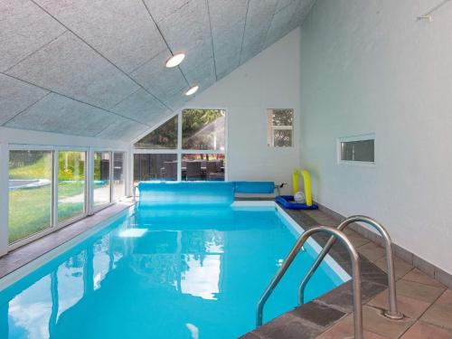 a swimming pool with blue water in a building at 12 person holiday home in Glesborg in Fjellerup Strand