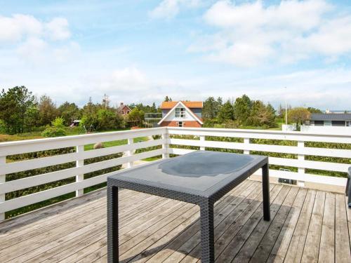 a black table on a wooden deck with a fence at 12 person holiday home in Glesborg in Fjellerup Strand