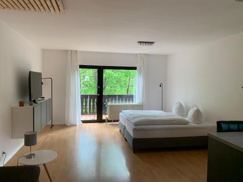 1 dormitorio con cama y ventana grande en Ferienwohnung am Ententeich en Bad Marienberg