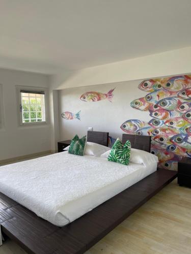 1 dormitorio con 1 cama grande con pescado pintado en la pared en Morin Forte dei Marmi, en Forte dei Marmi