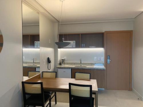 a kitchen with a wooden table and chairs at SALINAS EXCLUSIVE RESORT in Salinópolis