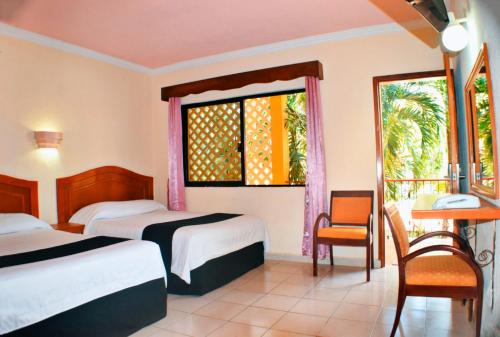 um quarto de hotel com duas camas e uma janela em Hotel Hacienda Sánchez em Valladolid