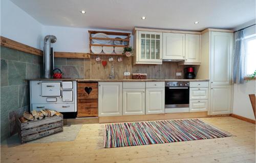 Una cocina con gabinetes blancos y una estufa. en Großes Ferienhaus Kolsassberg, en Kolsassberg