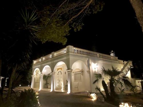 a large white building with lights on it at night at Masseria Principe di Puglia in San Vito dei Normanni