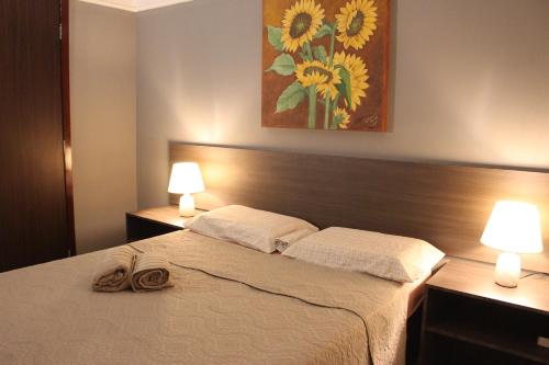 a bedroom with a bed with two lamps and a painting at Lindo Apartamento - Beira Mar de Boa Viagem in Recife