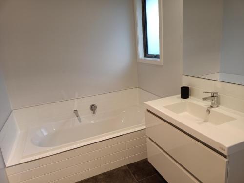 Baño blanco con bañera y 2 lavabos en Richmond, Nelson 3brm New Home en Richmond