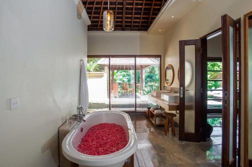 a bathroom with a bath tub filled with red rocks at Komaneka at Monkey Forest Ubud in Ubud