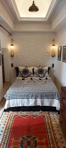 a bedroom with a large bed with a rug at Riad Barroko in Marrakech