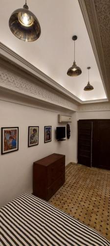 - une chambre avec un lit, deux lumières et une télévision dans l'établissement Riad Barroko, à Marrakech