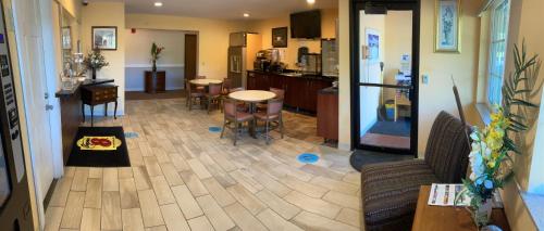 a living room with a table and chairs and a kitchen at Super 8 by Wyndham Chisago City in Chisago City