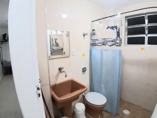 a small bathroom with a toilet and a sink at Sala-living/ 1 quadra da praia in Santos