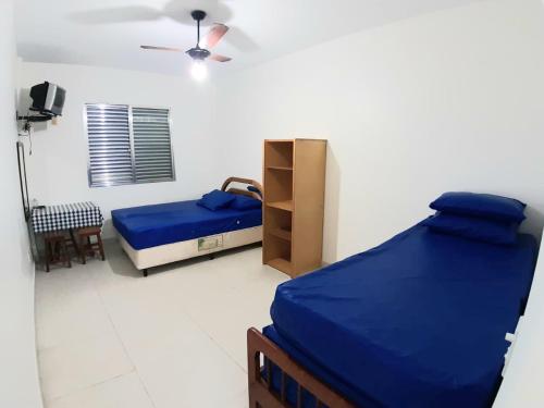 um quarto com 2 camas e uma ventoinha de tecto em Sala-living/ 1 quadra da praia em Santos