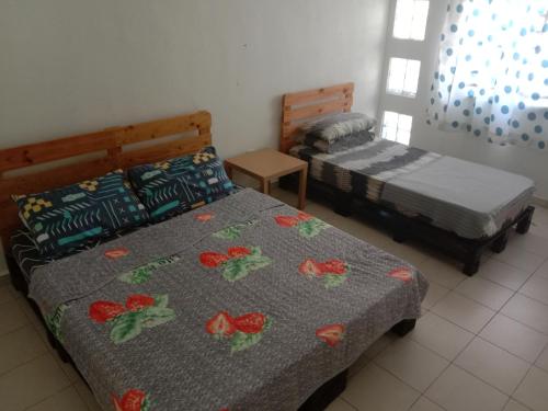 1 Schlafzimmer mit 2 Betten mit Blumen auf der Decke in der Unterkunft Maryam Kiara 2 in Kertih