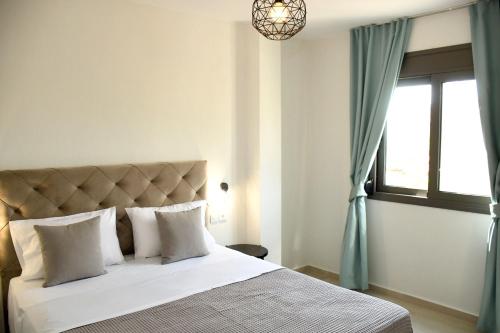 a bedroom with a large bed with a window at Theano Luxury Suites Nikiti in Nikiti