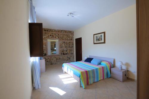 1 dormitorio con 1 cama con una manta colorida en Casa Vacanze Tenuta Trovante en Cortale