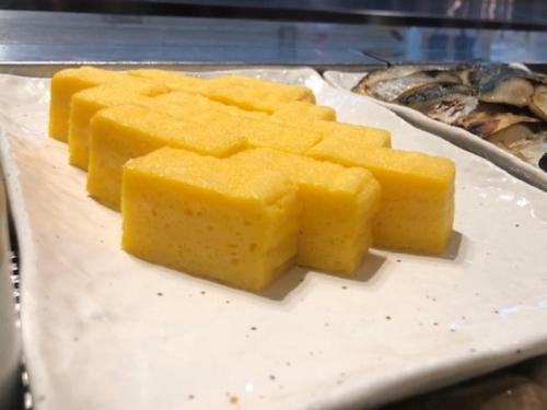 a bunch of cheese sticks on a plate with some food at Dormy Inn Hiroshima in Hiroshima