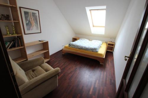 een kleine kamer met een bed en een bank bij Luxury Apartment in Sumava Mountains in Křišťanov