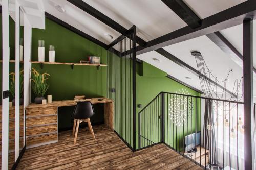 Zimmer mit grünen Wänden, einem Schreibtisch und einem Stuhl in der Unterkunft Двухуровневая квартира Черноморск для 5 человек in Tschornomorsk