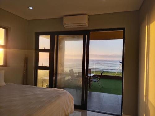 a bedroom with a bed and a view of the ocean at Qophelo Sea Views in La Mercy