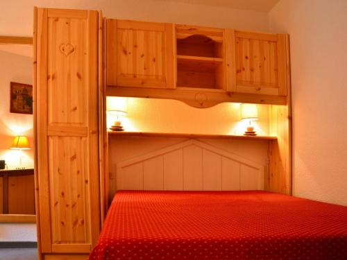 ベラントルにあるAppartement Bellentre, 3 pièces, 6 personnes - FR-1-329-15のベッドルーム1室(赤いベッド1台、木製キャビネット付)